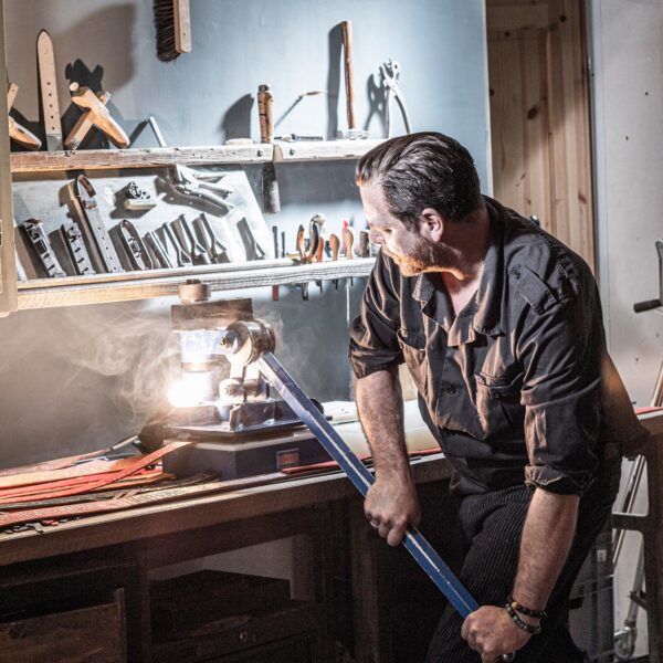 Using the leather punch in the Neptune's Jewels workshop.