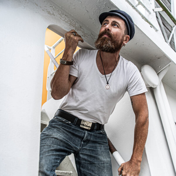 Sailor stands in the steps to the bridge and wears a belt with the Kiel Skyline belt buckle. Dimensions: approx. 5 x 7 cm, from Neptune Jewels.