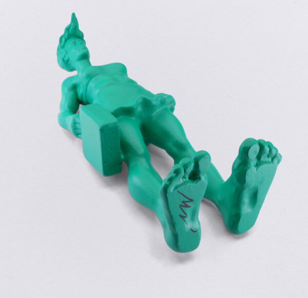 Miniatur der grünen Sylter Riesin, aus der Skulpurengruppe: Reisende Riesen im Wind, Bild zeigt die Unterseite der 10 cm großen grünen Figur mit der Handsignatur des Künstlers Martin Wolke.