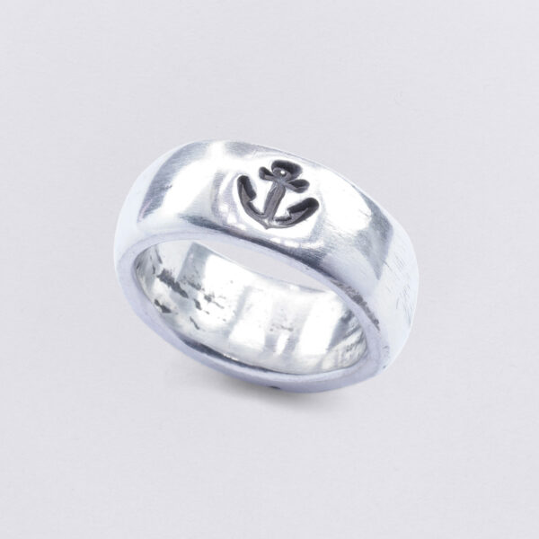 Band ring with smooth polished surface, wave structure and anchor embossing. Size approx. 14 x 25 mm. From Neptune Jewels.