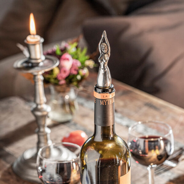 Flaschennixe Flaschenverschluss von Neptunsgeschmeide steckt als Flaschenverschluss in einer Rotweinflasche mit Gläsern und Kerzenlicht.