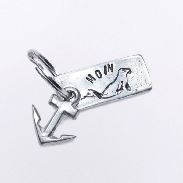 Kleiner Schlüsselanhänger mit einer Robbe und zusätzlichem Anker und Moin Prägung, Maße: 2 x 4,5 cm, von Neptunsgeschmeide.