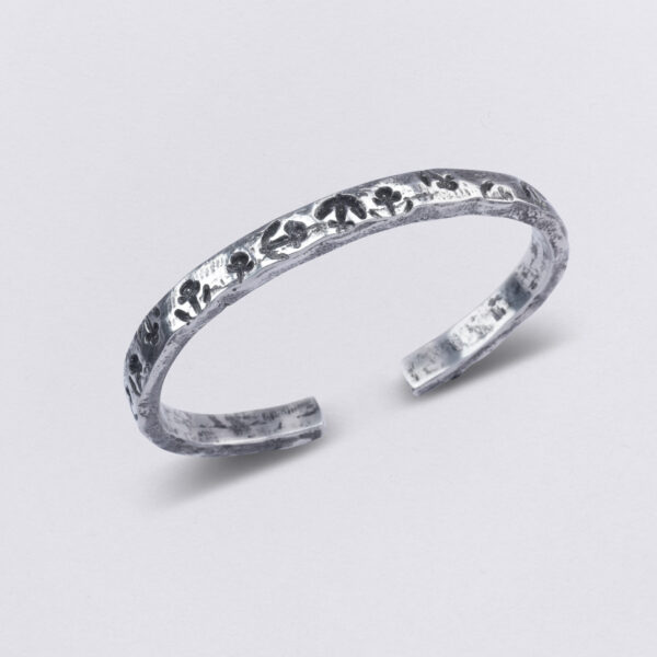 Bangle made of pewter with individual embossing: many anchors with the title: Anchor Swarm, by Neptune Jewels.