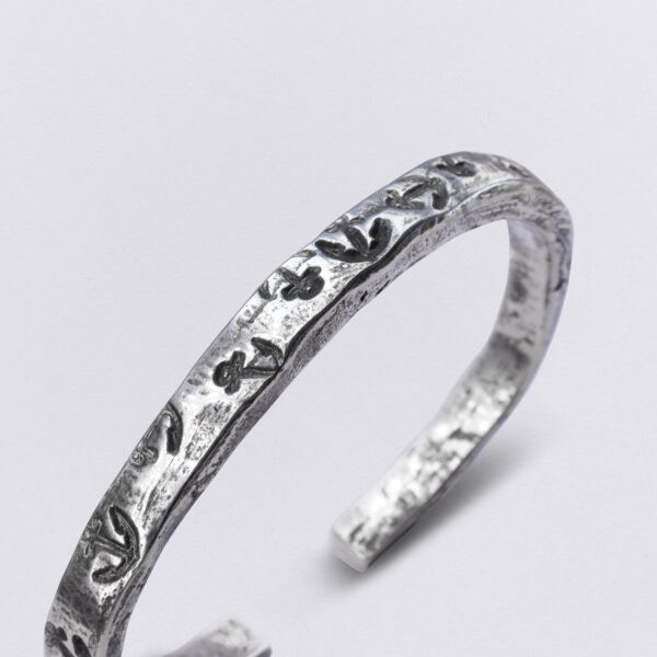 Bangle made of pewter with individual embossing: many anchors with the title: anchor swarm, detail view. From Neptune Jewels.