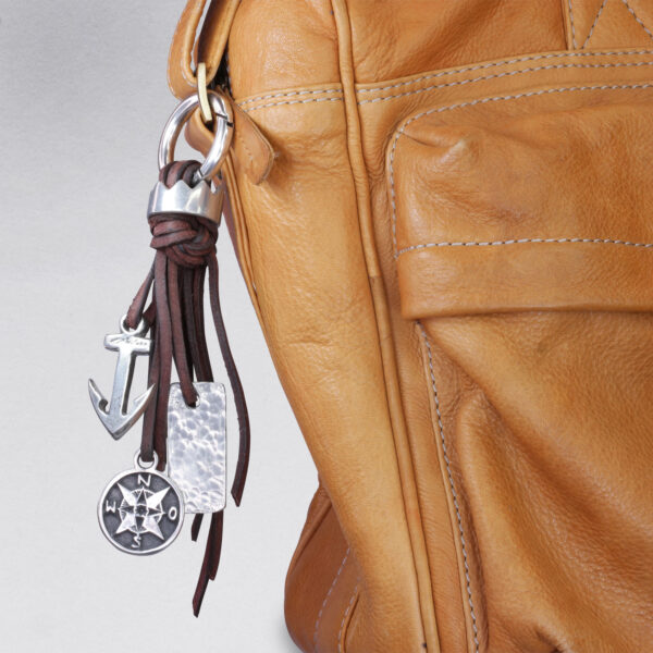 Gebamsel Anhänger Krone und Kompass, Detailbild an Ledertasche, von Neptunsgeschmeide. Taschen- oder Schlüsselanhänger mit Karabinerhaken klein.