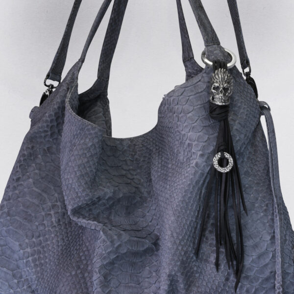 Gebamsel® Anhänger Totenkopf Flammenherzen, Beispielbild an Tasche Blau, Detail, von Neptunsgeschmeide. Taschen- oder Schlüsselanhänger mit kleinem Ring an Lederschnürung mit Karabinerhaken gerade Kanten, groß.