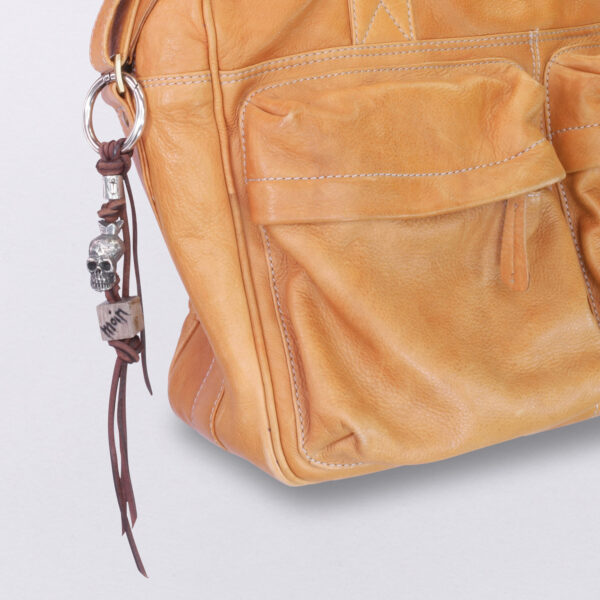Gebamsel® Anhänger Totenkopf König Holzwürfel, Ansicht an Beispieltasche, Detail, von Neptunsgeschmeide. Taschen- oder Schlüsselanhänger mit Karabinerhaken, groß.