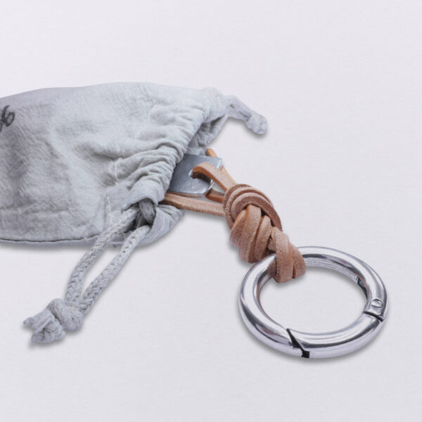 Verpackung eines Gebamsel® Schlüssel und Taschenschmucks in einem hand gestempelten Baumwollbeutel von Neptunsgeschmeide in Detailansicht.