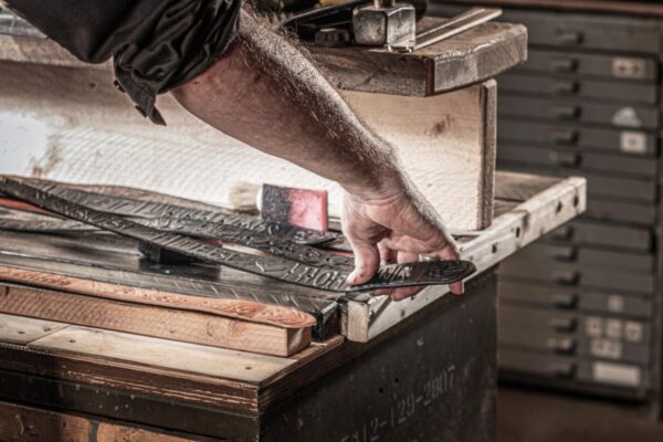 Neptunsgems atelier en atelier: Randen van de geverfde leren banden worden met de hand geverfd.