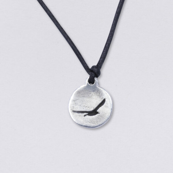 Necklace seagull on leather cord. On a black, round 2 mm leather strap from NeptunsSchmeiße. Pendant size: approx. 17 mm in diameter. Main image blacked out.