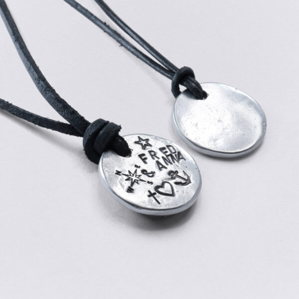 Customizable embossing on a blank necklace pendant on a black leather strap by NeptunsSchmeide.