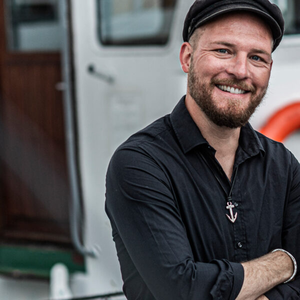 Ankarhänge: Neptunus vän på en fyrkantig svart läderrem med justerbar knutstängning. Bären av en sjöman i hamn. Från Neptune Jewels.