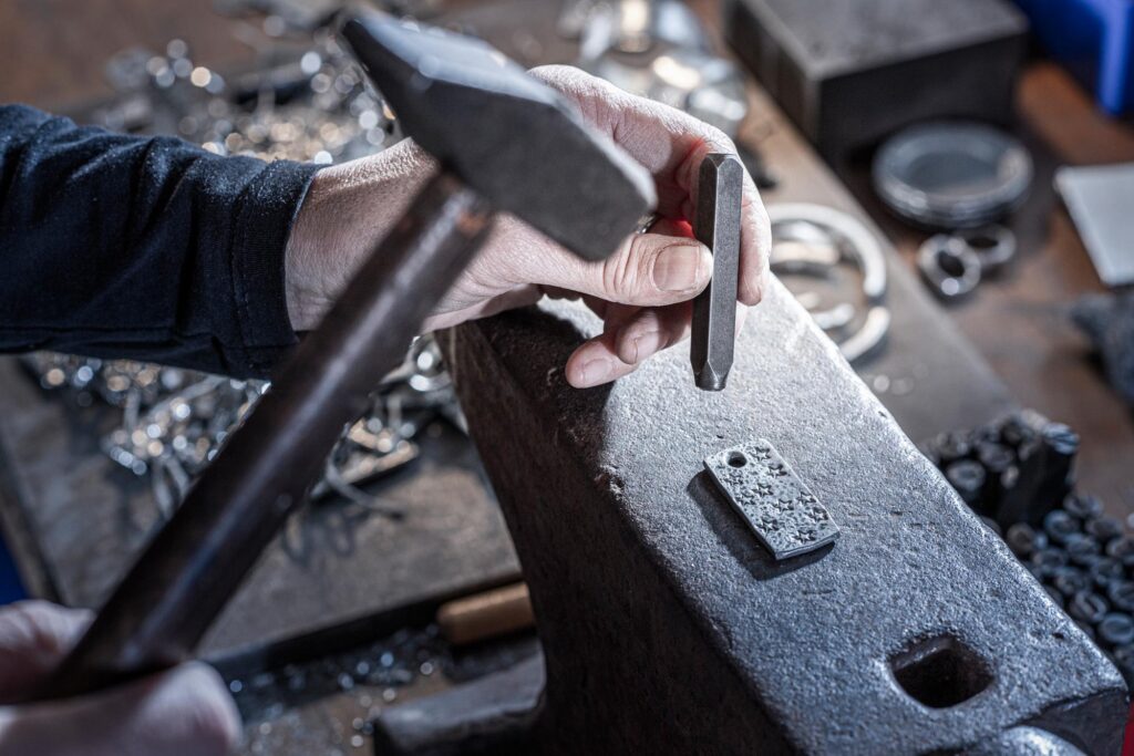 Neptunsgeschmeide Werkstatt und Atelier: Herstellung eines Schlüsselanhängers. Handprägung von Sternen in den Zinn.