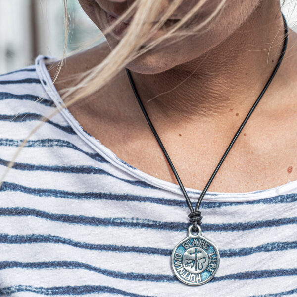 Ketting geloof liefde hoop aan leren koord. op de zwarte, ronde 2 mm leren band van NeptunsSchmeiße. Afmeting hanger: ongeveer 3 cm in doorsnee. Afbeelding van bovenaf gedragen door vrouw.