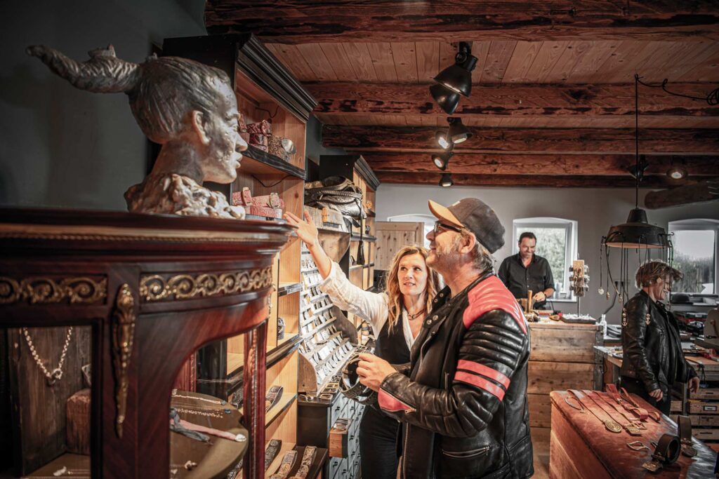 Neptunsgeschmeide Showroom. Ladenbereich, Kunde wird von Jen Wolke beraten und betrachtet die Auslage in einem Regal.