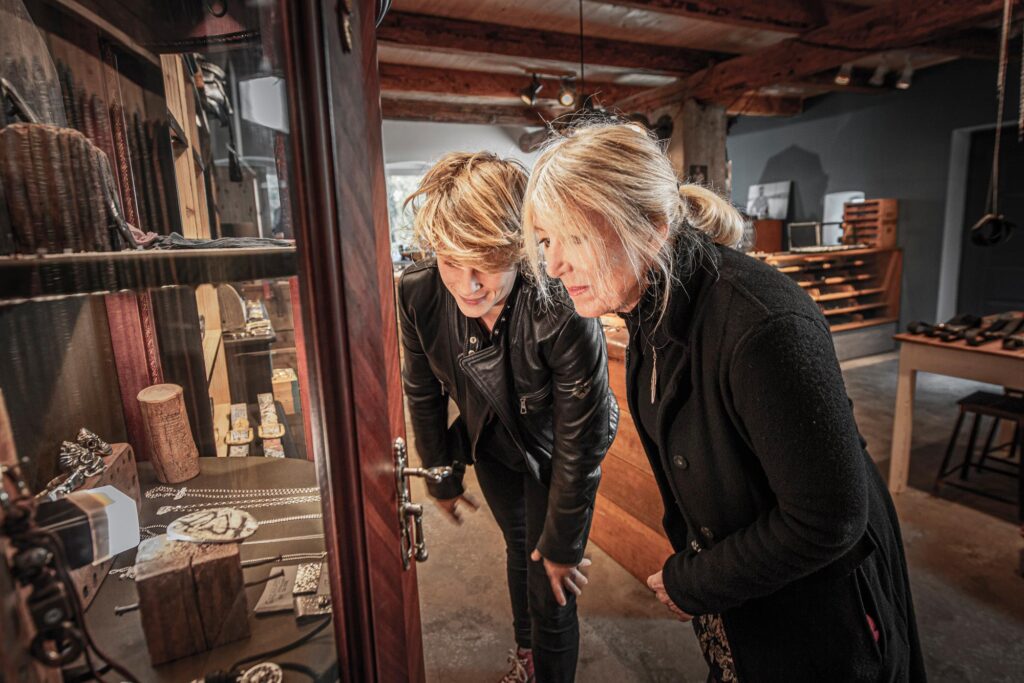 Neptunsgeschmeide Showroom. Ladenbereich, Kundinnen betrachten die Auslage in einer Vitrine.