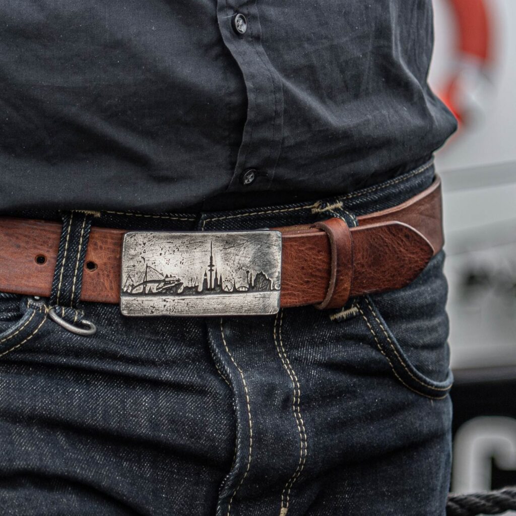 Nussbrauner Gürtel mit Skyline Hamburg Gürtelschnalle, Maße. ca. 9 x 4,5 cm. Bild zeigt Hamburger mit Gürtel.