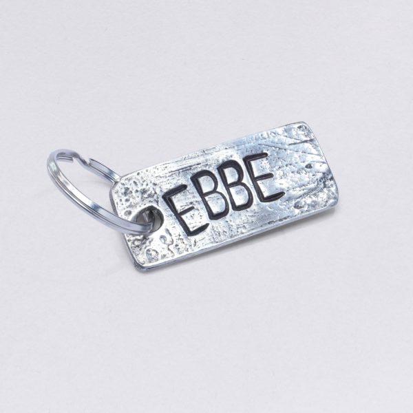 Schlüsselanhänger mit Prägung Ebbe, Maße: ca. 2 x 4,5 cm, von Neptunsgeschmeide. Individualisierbar mit Wunschprägung.