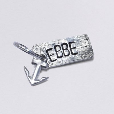 Schlüsselanhänger mit Prägung Ebbe mit kleinem Anker, Maße: ca. 2 x 4,5 cm, von Neptunsgeschmeide. Individualisierbar mit Wunschprägung.