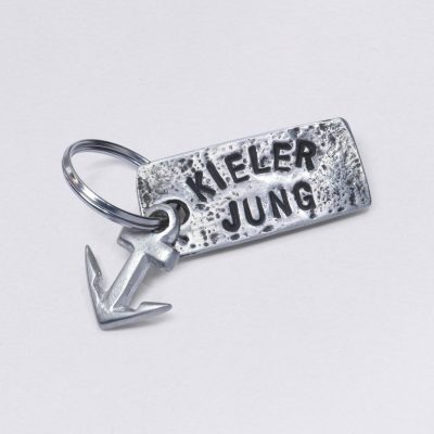 Schlüsselanhänger mit Prägung Kieler Jung mit kleinem Anker, Maße: ca. 2 x 4,5 cm, von Neptunsgeschmeide. Individualisierbar mit Wunschprägung.