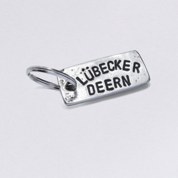 Key ring with Lübecker Deern embossing, dimensions: approx. 2 x 4,5 cm, from NeptunsSchmeide. Customizable with desired embossing.