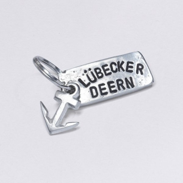 Key ring with embossing Lübecker Deern with a small pewter anchor, dimensions: approx. 2 x 4,5 cm, from Neptunsschmeide. Customizable with desired embossing.