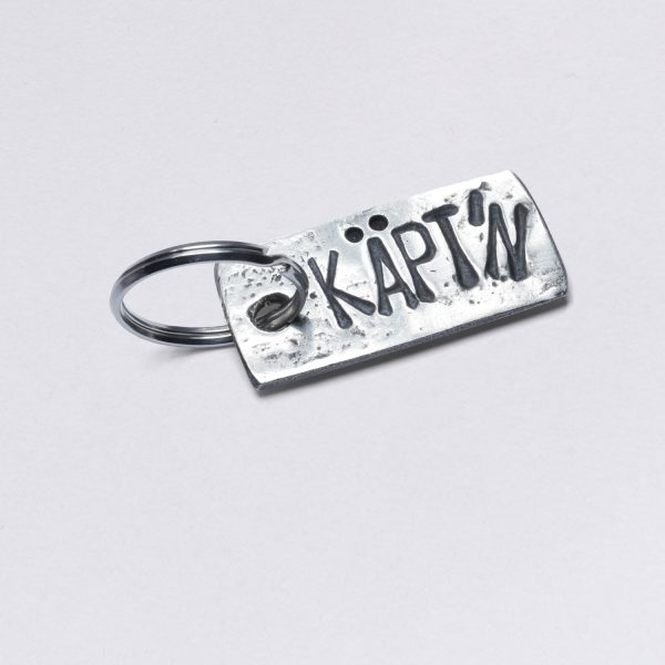 Schlüsselanhänger mit Prägung Käpt´n für Kapitän, Zinn mit Einschlüssen, Maße: ca. 2 x 4,5 cm, von Neptunsgeschmeide. Individualisierbar mit Wunschprägung.