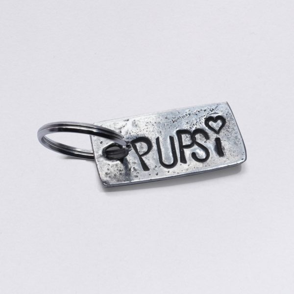 Key ring with Pupsi embossing, pewter with inclusions, dimensions: approx. 2 x 4,5 cm, from NeptunsSchmeiße. Customizable with desired embossing.