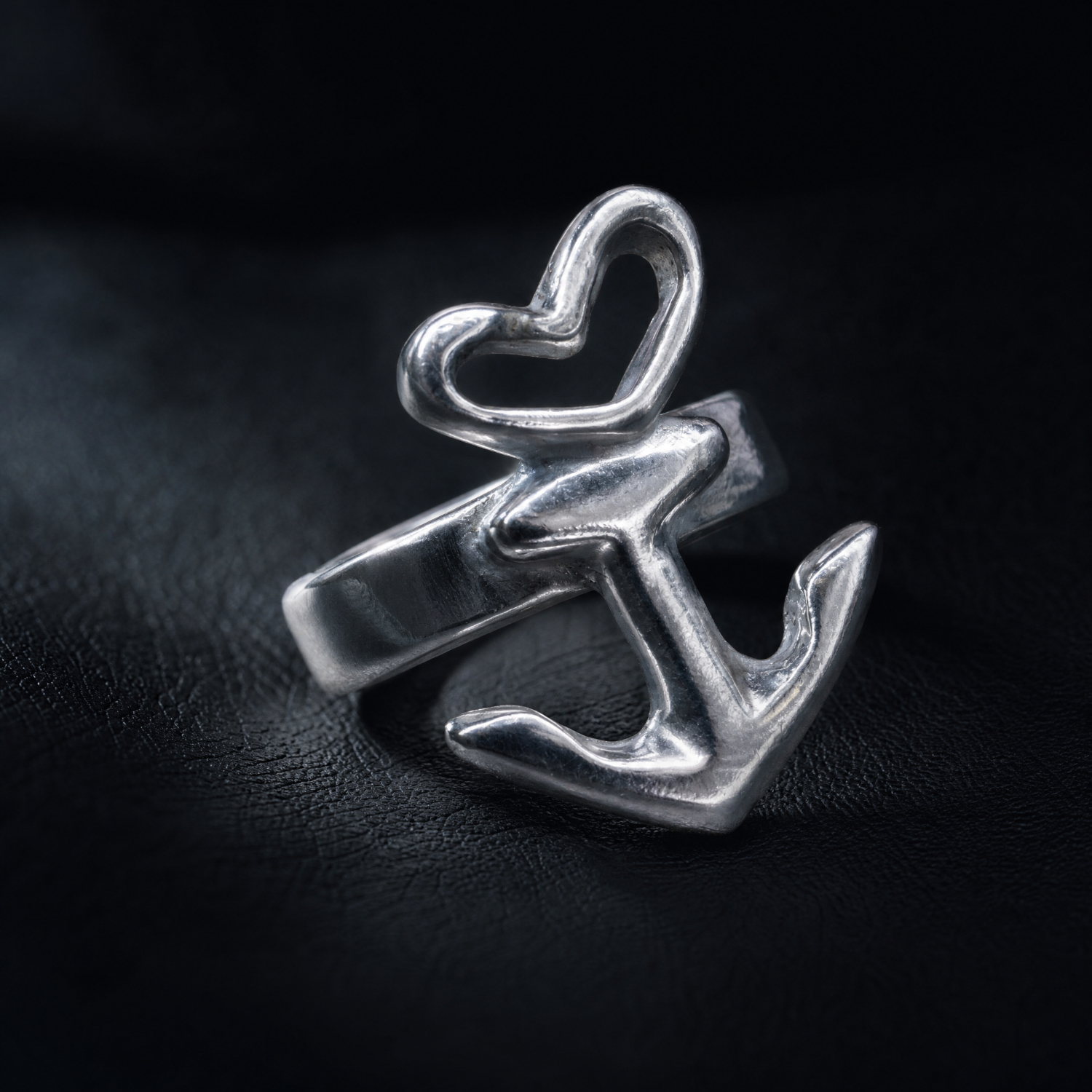 Motivring Herz Anker freistehend, Zinn oder Silber, Handarbeit von Neptunsgeschmeide mit optionaler Innengravur. Detailbild liegend schräg von vorn.