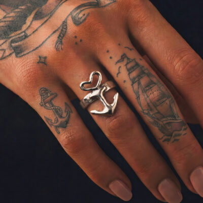 Motivring Herz Anker freistehend, Zinn oder Silber, Handarbeit von Neptunsgeschmeide mit optionaler Wunschprägung außen. Detailbild Motivring an weiblicher Hand, Nahaufnahme.