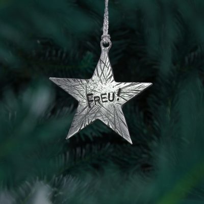 Baumschmuck Stern Freu!, Weihnachtsstern mit Frecher Textprägung und mit optionaler Wunschprägung aus Zinn. Maße ca. 8 x 8 cm. Von Neptunsgeschmeide. Ansicht am Baum hängend.