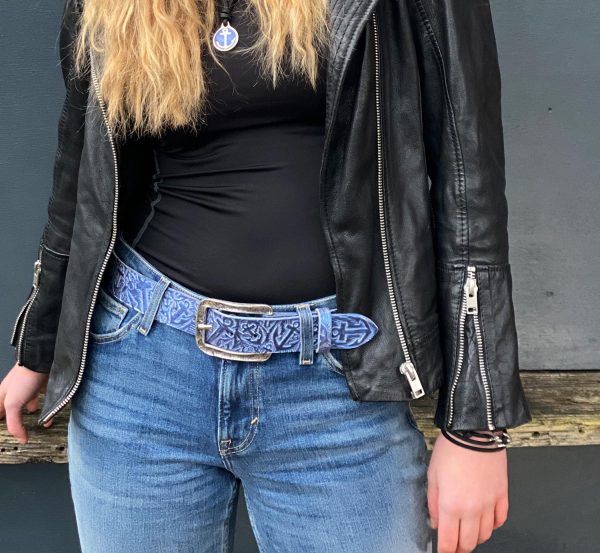 Hand-embossed belt with anchor motif, anchor belt shimmering blue with belt buckle Surf in antique silver. From Neptune Jewels. Picture shows a model standing with the belt on the jeans.