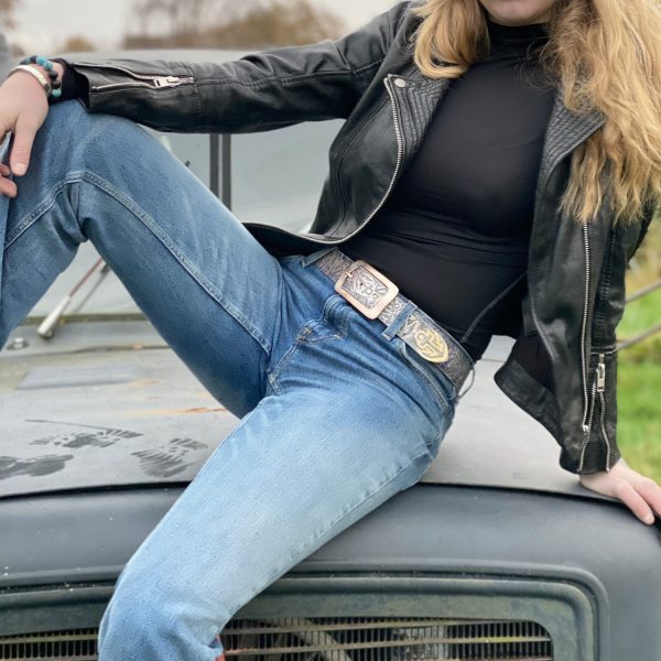 Hand-embossed belt with anchor motif, anchor belt multicolored with belt buckle Ebbe rose-colored. From Neptune Jewels. Picture shows a model sitting on an old timer truck.