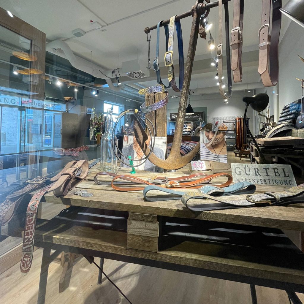 Im Schaufenster des Pop Up Stores von Neptunsgeschmeide in List auf Sylt werden Gürtel Ketten und Gürtelschnallen angeboten.