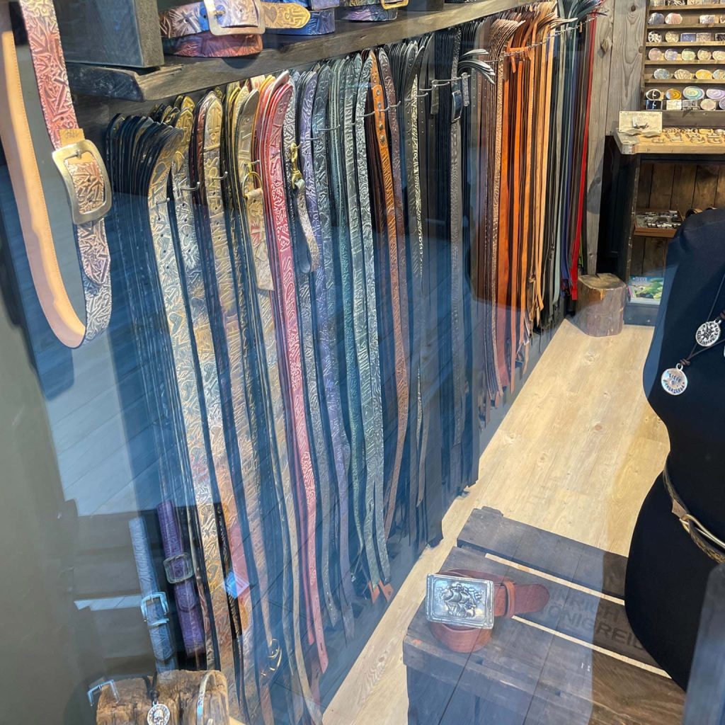 Blick in das Schaufenster von Neptunsgeschmeide im Lister Markt auf Sylt. Eine reichhalttige Auswahl von Ledergürteln und Gürtel ist anzuschauen.