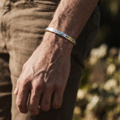 Koordinaten Armreif von Neptunsgeschmeide. Getragen am Handgelenk eines Mannes.