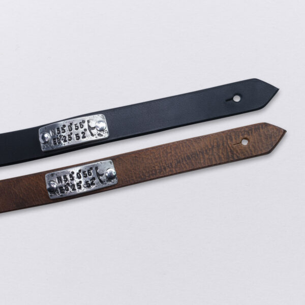 Koordinaten Sylt Armband von Neptunsgeschmeide. Ein Hand-geprägtes Zinnplättchen ist auf einem Lederarmband mit Knopfnietenverschluss vernietet. Abbildung zeigt die Koordinaten von List auf Sylt. Farbauswahl schwarz und braun.