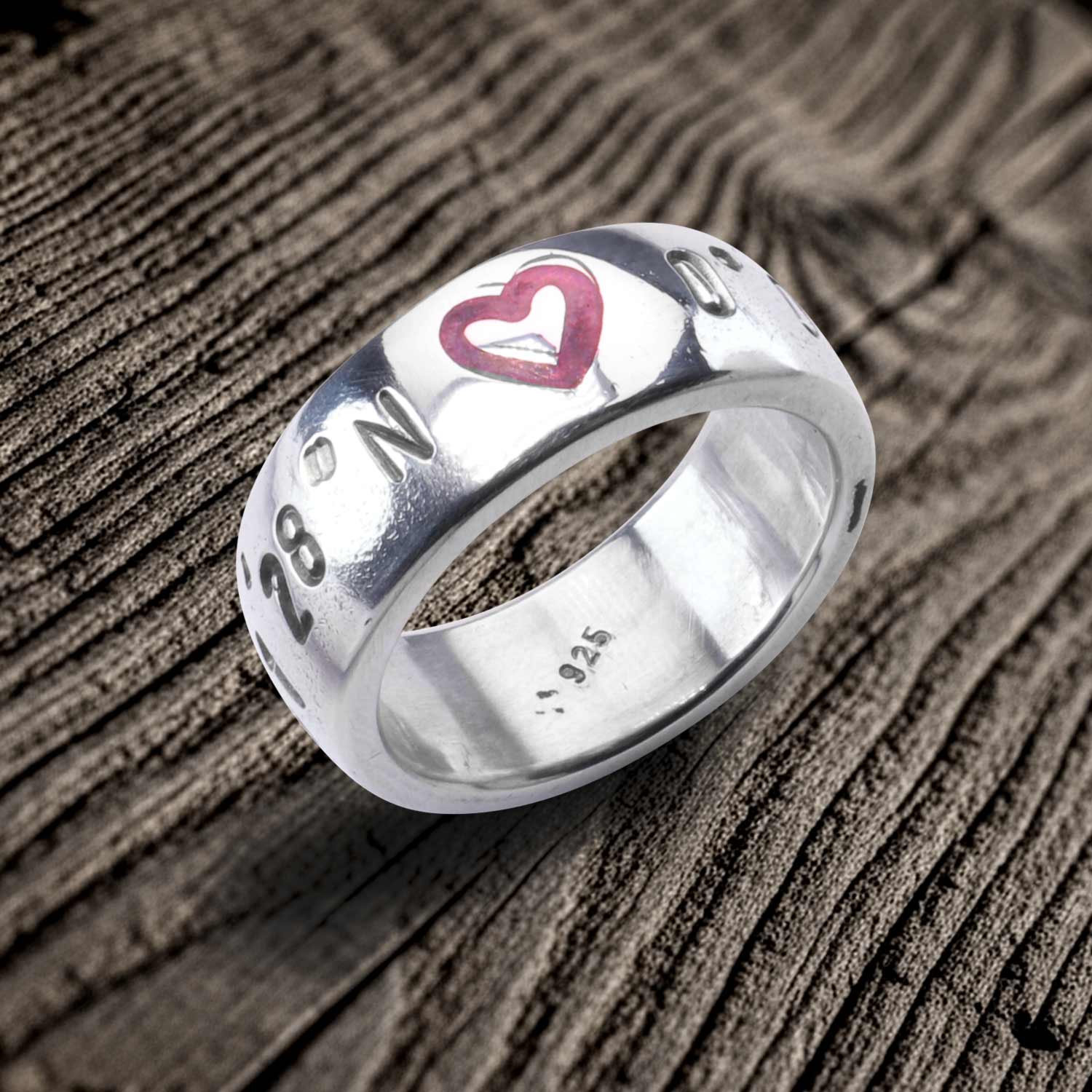 Koordinaten Bandring von Neptunsgeschmeide mit polierter Oberfläche und Herzsymbol mit pinker Gießharzfüllung. Angefertigt in 925er-Silber.